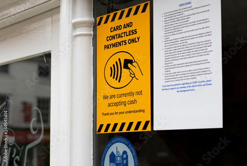 Obraz na plátne Retailer displaying sign in shop window not accepting cash payments and only acc