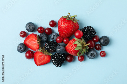 Fototapeta Naklejka Na Ścianę i Meble -  Mix of fresh berries on blue background, top view