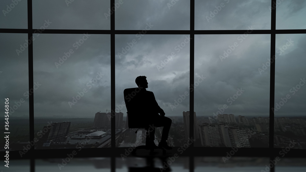 The business man is sitting in the office near the window with a scenic sky view The business man is sitting in the office near the window with a scenic sky view