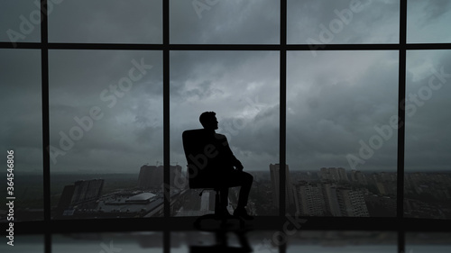 The business man is sitting in the office near the window with a scenic sky view © realstock1
