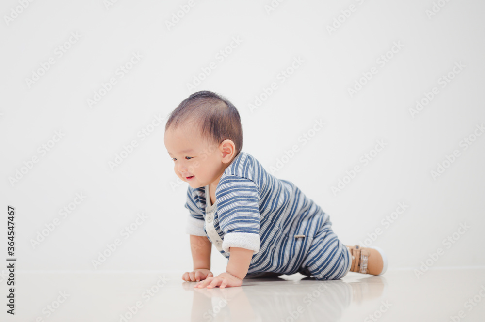 Smiling crawling asian baby boy at home on floor with white background. Smiling crawling asian baby boy at home on floor with white background.