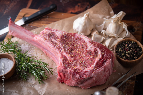 Bild auf Leinwand seasoned tomahawk steak meat on wooden board