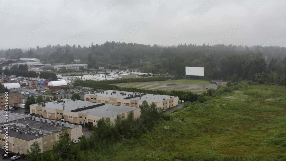 Aerial panaramic left from empty agricultural lands to industrial parks on a rainy summer morning right by a wet drive in theatre. Aerial panaramic left from empty agricultural lands to industrial parks on a rainy summer morning right by a wet drive in theatre.