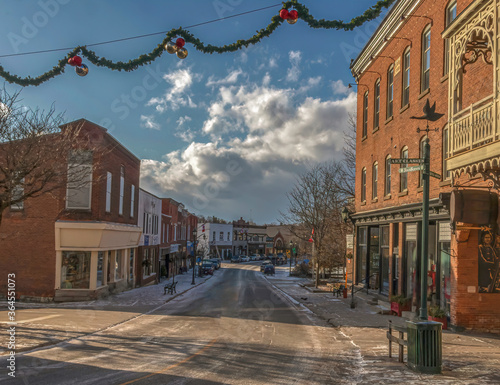 Deserted small town Main Street late afternoon sun and shadows on street, storefronts, brick buildings and Christmas decorations nobody photo