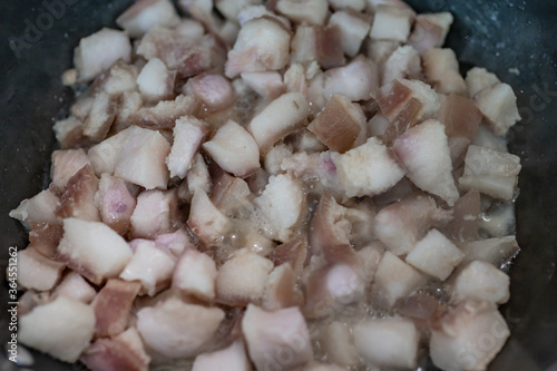Homemade Crackling and lard (Pork oil) are fried in hot pan. It made from scrap of pork in small piece. Organic fat food.