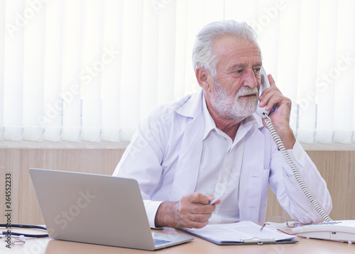 Senior doctor giving advise to a patient via phone