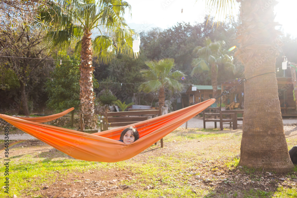 The boy lies in a hammock. The boy lies in a hammock.