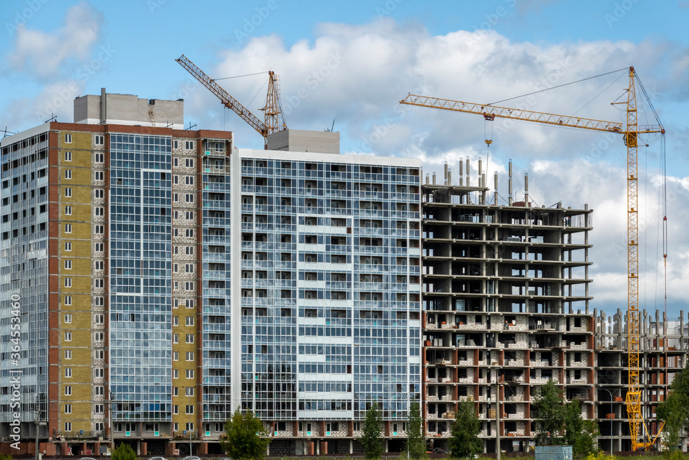 Frame construction of a high-rise building. Part of the building is built, but the unfinished part of the exterior walls between the slabs are covered with bricks. Frame construction of a high-rise building. Part of the building is built, but the unfinished part of the exterior walls between the slabs are covered with bricks.
