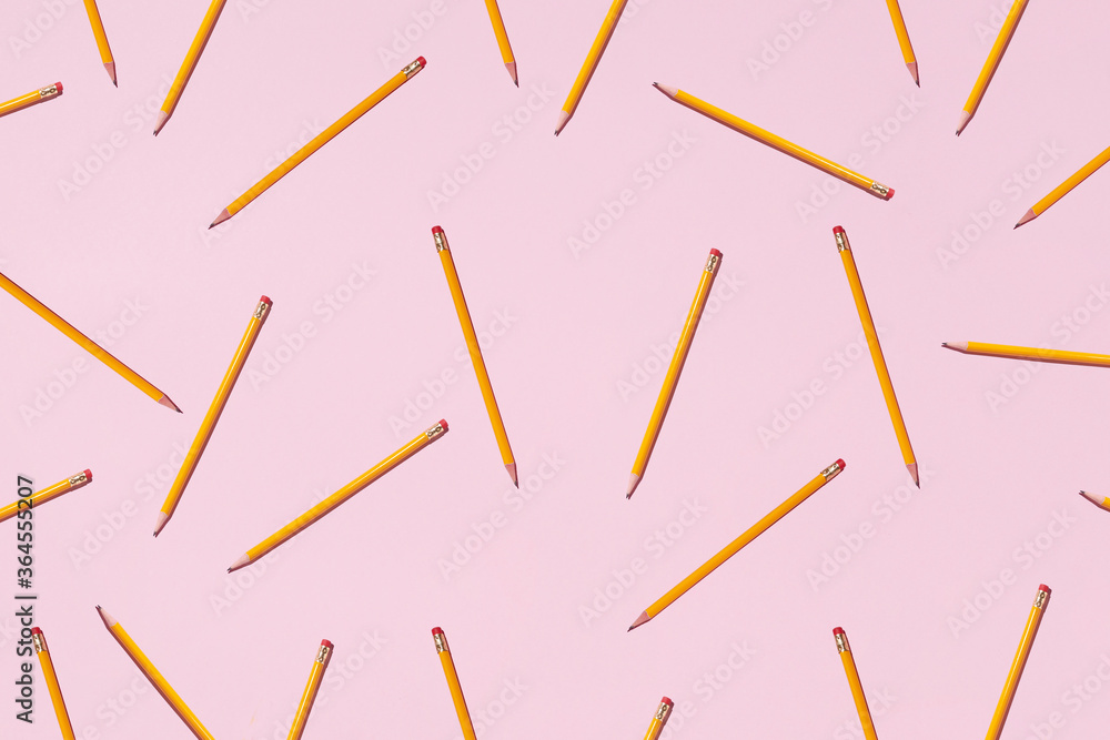 Top view of seamless background of pencils chaotically scattered on pink surface Top view of seamless background of pencils chaotically scattered on pink surface