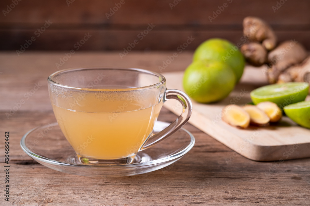 Hot Ginger juice with lime fruit and slices of ginger on cutting board,healthy Drink Hot Ginger juice with lime fruit and slices of ginger on cutting board,healthy Drink