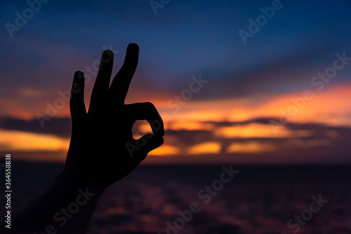 ok sign shown by hand on sunset background © Konstantin