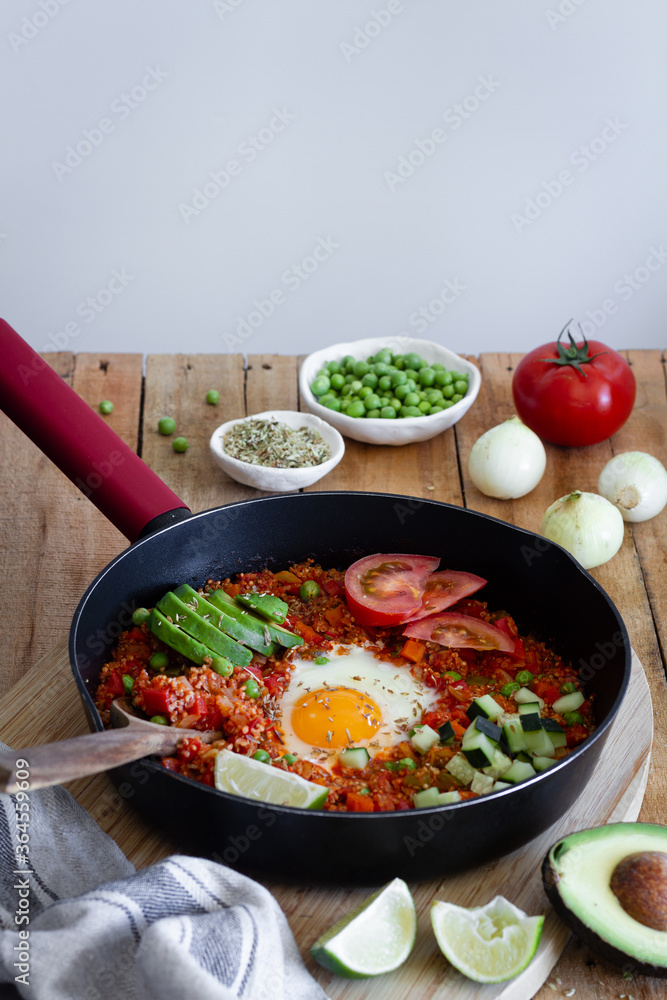Tasty shakshuka with eggs and quinoa placed on table with fresh ingredients Tasty shakshuka with eggs and quinoa placed on table with fresh ingredients