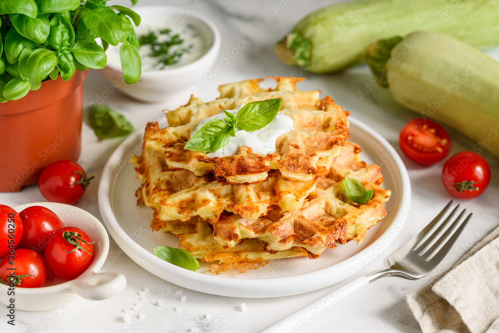 Zucchini cheese waffles with sour cream sauce with garlic and dill. Selective focus Zucchini cheese waffles with sour cream sauce with garlic and dill. Selective focus