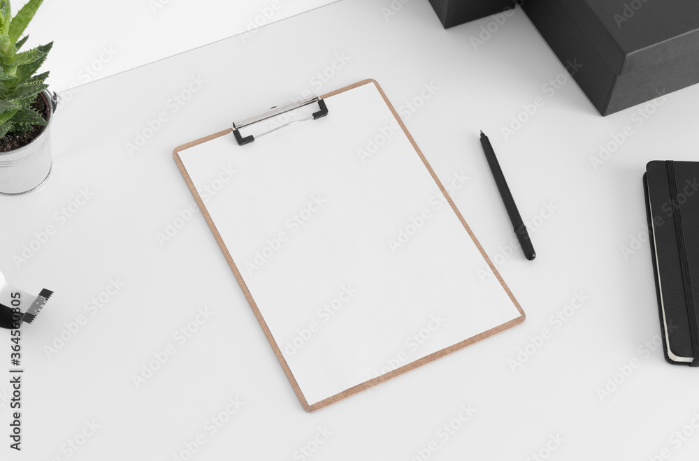 Wooden clipboard mockup wtih workspace accessories on a white table. Wooden clipboard mockup wtih workspace accessories on a white table.