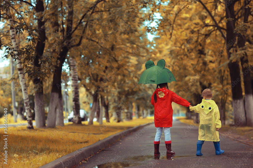 children brother and sister play autumn rain / October weather little children walk in the city children brother and sister play autumn rain / October weather little children walk in the city