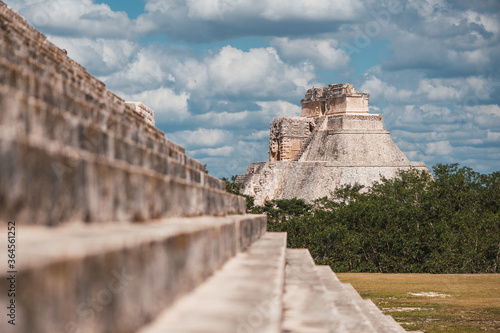 Exterior of stone steps of El Castillo with view of pyramid under cloudy sky in Chichen Itza photo