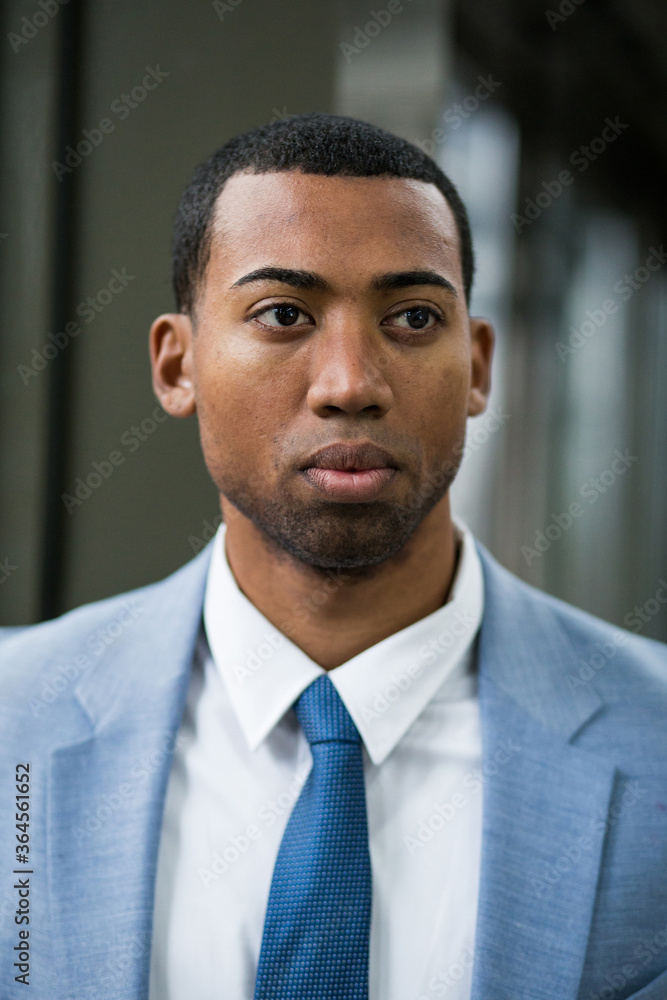 Close-up portrait of handsome serious African-American man in trendy blue suit and tie looking away pensively. Close-up portrait of handsome serious African-American man in trendy blue suit and tie looking away pensively.