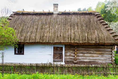 GUCIOW, POLAND - MAY 3, 2016: Old log cabin in an open-air ethnography museum in Guciow, Poland. Heritage park is located next to the forest and immitates typical Polish village from past centuries. photo