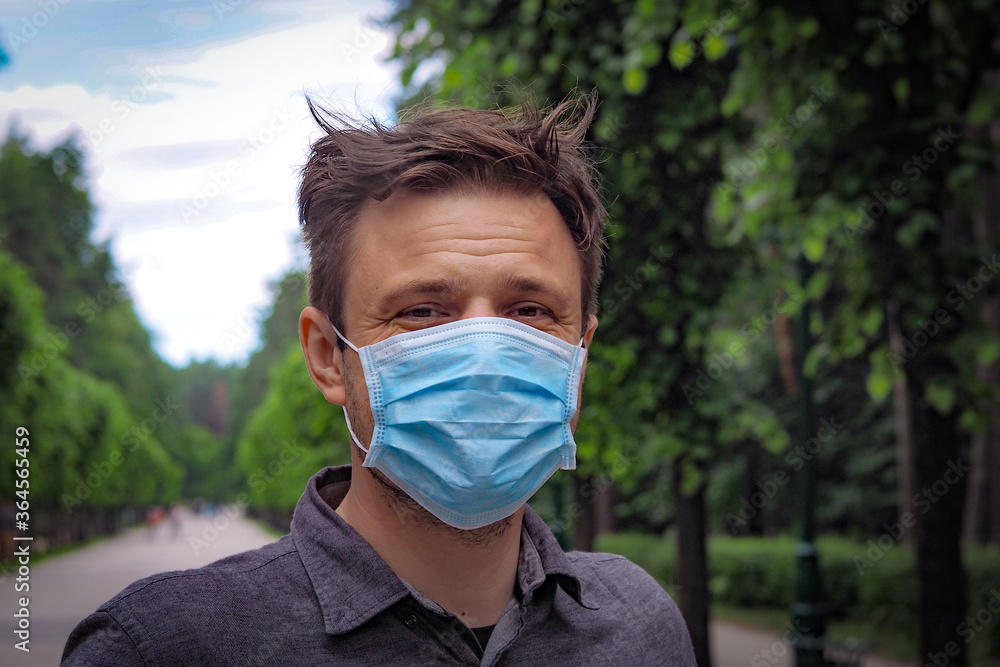 Handsome young European man smiling with a medical face mask on. Closeup of a 35-year-old male in a respirator to protect against Covid-19 Handsome young European man smiling with a medical face mask on. Closeup of a 35-year-old male in a respirator to protect against Covid-19