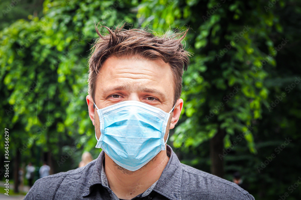 Handsome young European man smiling with a medical face mask on. Closeup of a 35-year-old male in a respirator to protect against Covid-19 Handsome young European man smiling with a medical face mask on. Closeup of a 35-year-old male in a respirator to protect against Covid-19