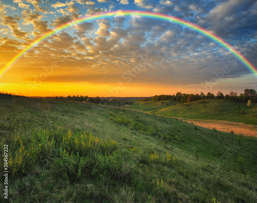 Rainbow over the meadow. picturesque spring morning