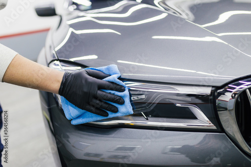 A man cleaning car with microfiber cloth, car detailing (or valeting) concept. Selective focus. © hedgehog94