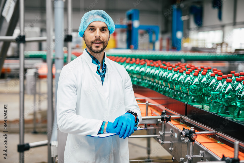 Male worker in bottling factory checking water ottles before shipment. Inspection quality control. Male worker in bottling factory checking water ottles before shipment. Inspection quality control.