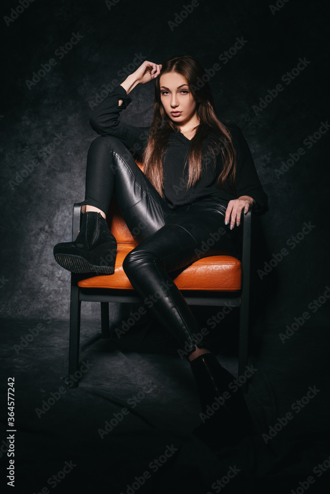 Beautiful brunette in the studio on a dark background in a photo studio Beautiful brunette in the studio on a dark background in a photo studio