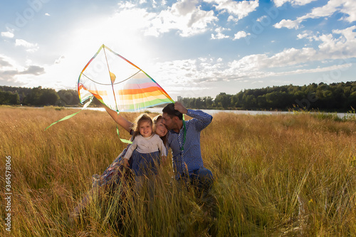 Family launches kite against beautiful sky