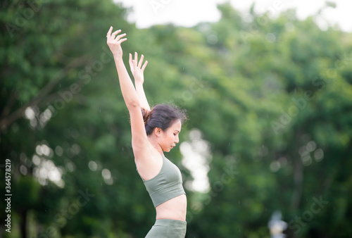 Asian model poses yoga in a park on a natural green background  health care concept  beautiful body structure  fit body