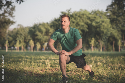 Guy stretching legs during warming-up for jogging