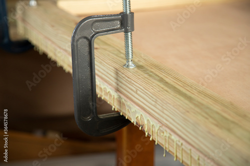 A g-clamp fastening glued pieces of stock together