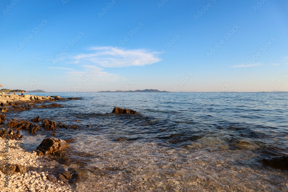 Vrgada island far in the distance on the horizon of beautiful, blue adriatic sea off the coast of Pakostane town, Croatia