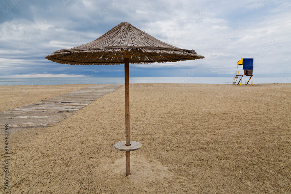 Beach umbrella and lifeguard hut along the Adriatic Sea, in Durres, Albania Beach umbrella and lifeguard hut along the Adriatic Sea, in Durres, Albania