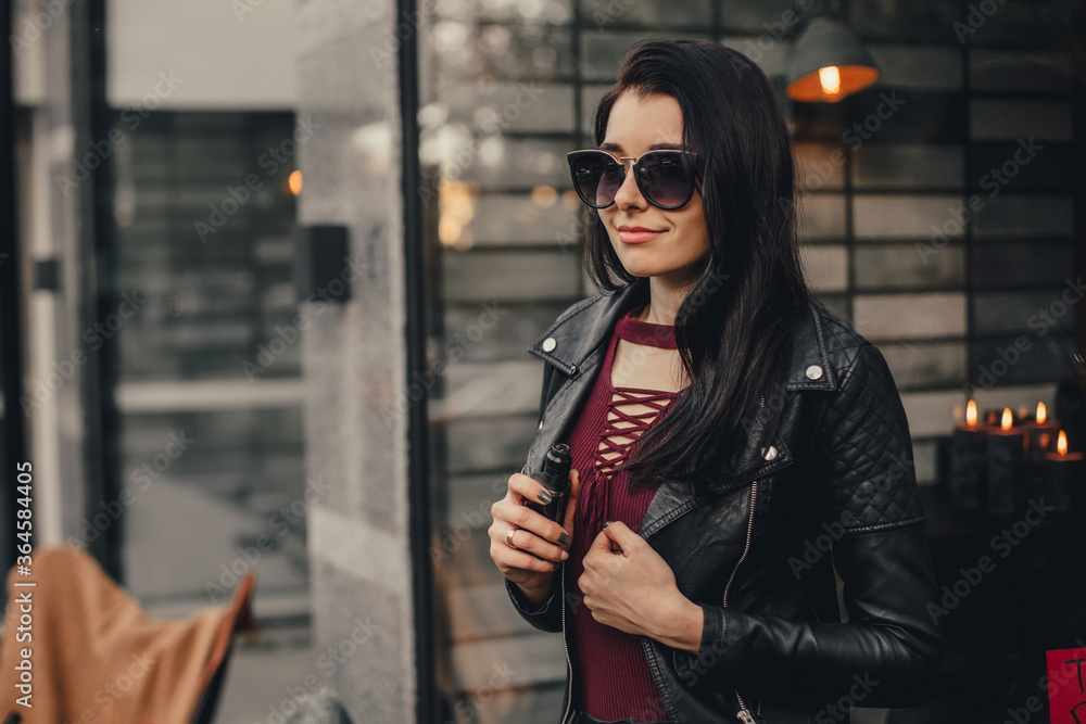 Obraz premium Beautiful stylish brunette with e-cigarette. Vaping concept.