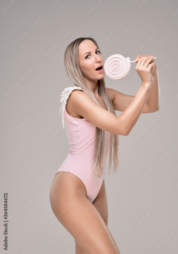 Beautiful slim and fit girl with long blond hair in pink swimsuit. Glowing skin Beautiful slim and fit girl with long blond hair in pink swimsuit. Glowing skin