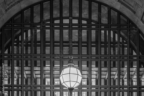 Arched Double Window with Grid Pattern Panes and Geometrical Light Fixture