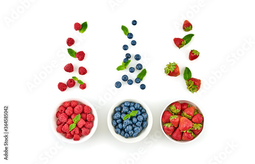 Blueberry, raspberry, strawberry in bowl isolated on white. Fresh blueberry, berries closeup. Ripe red raspberry, strawberry, mint creative composition. Colorful trendy concept, top view.