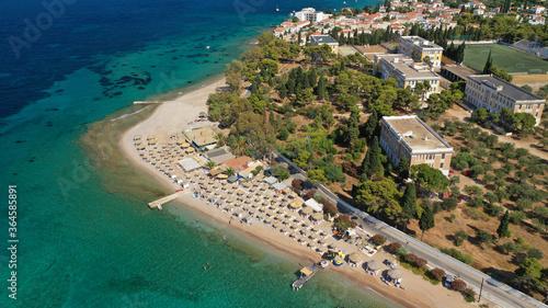 Aerial drone photo of organised with sun beds emerald beach of Kaikia in Ligoneri area near old town of Spetses island, Saronic gulf, Greece