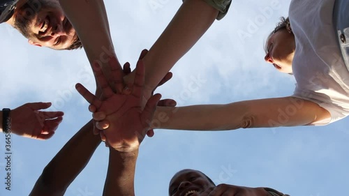 Close portrait of crossed arms interracial group of youth, different skin color. Friendly support, equality and fraternity, a symbol of the movement against racism