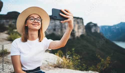 Obraz na plátně blonde female traveler in summer hat communication by video call on digital devi