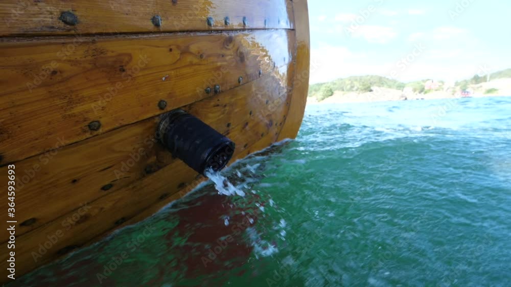 Water Bursting Out Of The Exhaust Pipe Of A Wooden Boat Cruising On The Clear Blue Sea In Norway - close up Water Bursting Out Of The Exhaust Pipe Of A Wooden Boat Cruising On The Clear Blue Sea In Norway - close up
