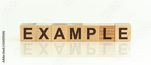 Word EXAMPLE made with wood building blocks, white background