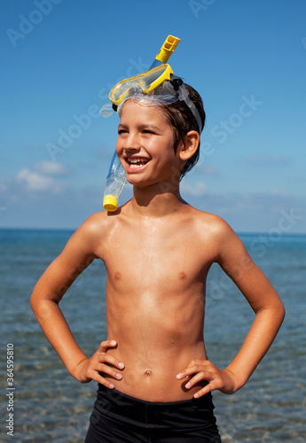 Smiling boy wearing snorkel and goggles on beach