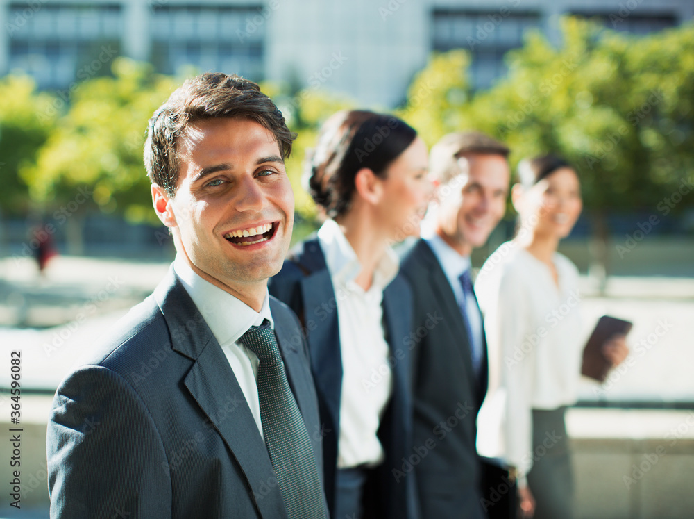 Happy businessman walking with colleagues outdoors Happy businessman walking with colleagues outdoors