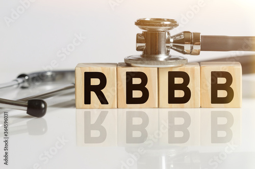 RBBB the word on wooden cubes, cubes stand on a reflective white surface, on cubes - a stethoscope. photo