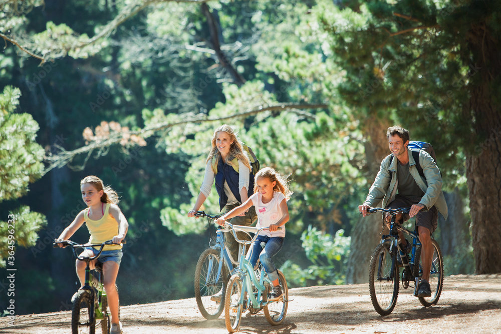 Obraz premium Smiling family bike riding in woods