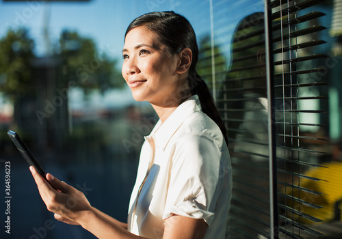Smiling businesswoman using digital tablet outdoors