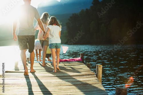 Fotomurale Family walking on dock over lake