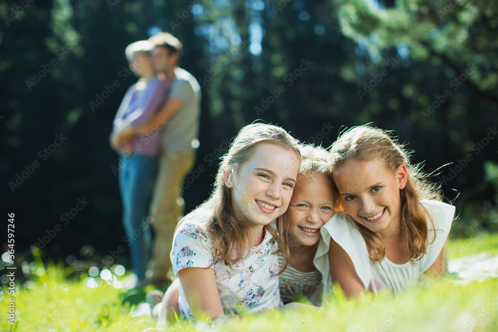 Naklejka premium Smiling girls laying in grass